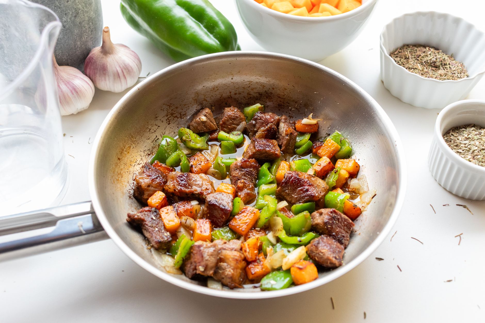 Poêle en inox, vraiment dangereuse — poêle en inox cuisinant des légumes