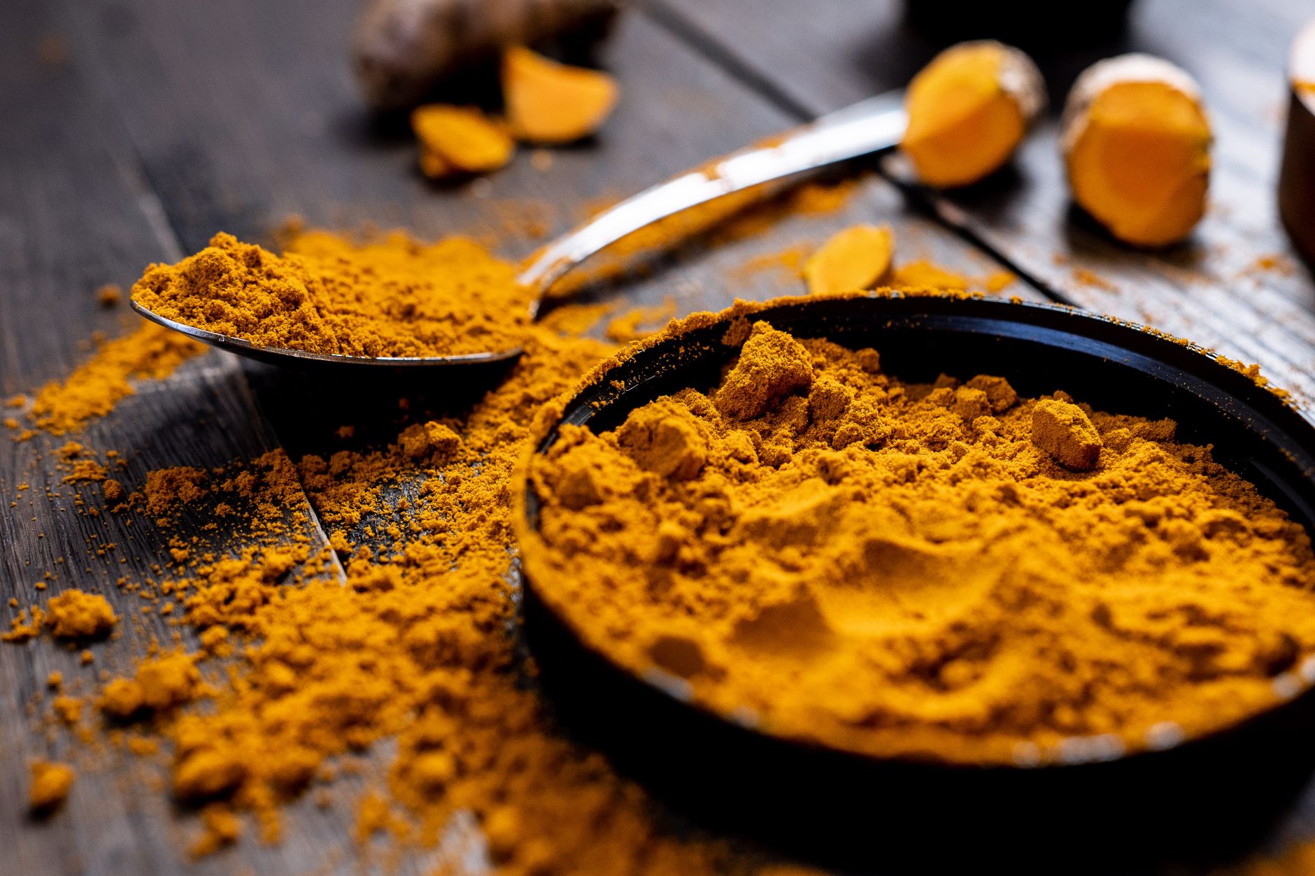 Curcuma et foie fragilisé : quand l’épice dépasse les bornes — racine et poudre de curcuma sur table en bois