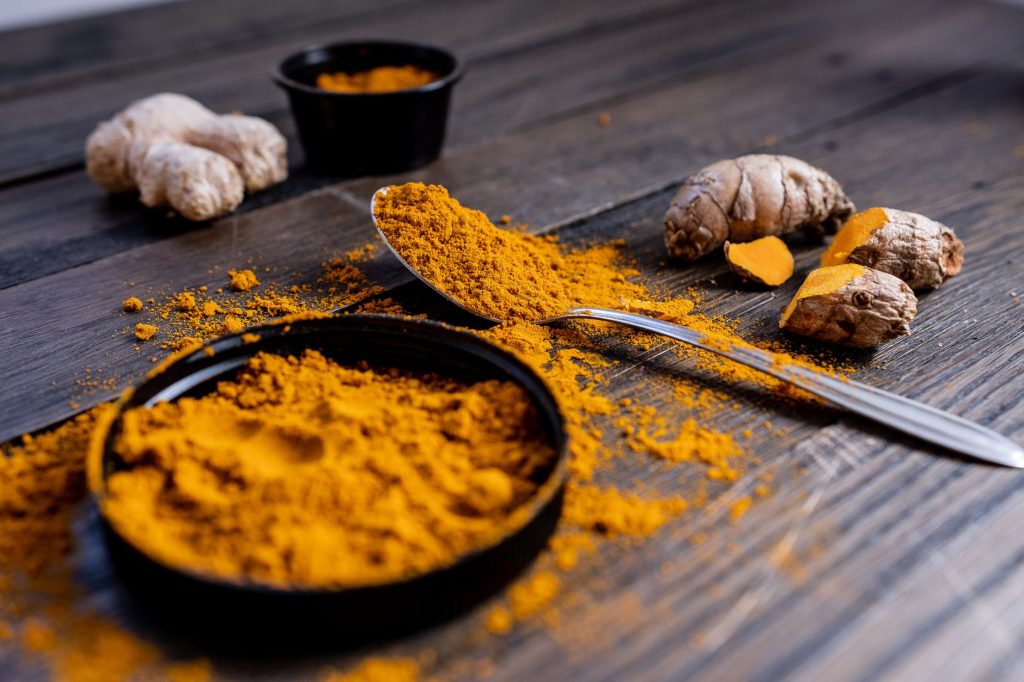 Curcuma dangers, effets secondaires et — racine et poudre de curcuma sur table en bois